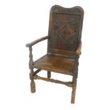 An 18thC oak Wainscot type chair, with carved back, open arms, boarded seat, turned and square frami