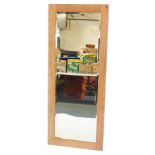 A rectangular pine framed wall mirror, with bevelled plate, 141cm high, 55cm wide.