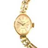 A 9ct gold Everite lady's wristwatch, with small oval watch head, on three bar bracelet, the dial 1c