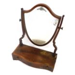 A George III flame mahogany serpentine dressing table mirror, with shield shape plate, cross banded