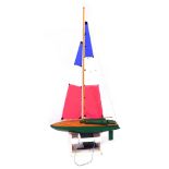 A radio controlled wooden model of a yacht, with a green and wooden planked hull, fully rigged sale,