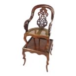 An early 19thC mahogany child's high chair, with scroll arms and pierced vase splat, on square secti