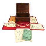 A cased mah-jong set, in a carved oak fitted box, with leaf moulded detail, opening to reveal a fitt
