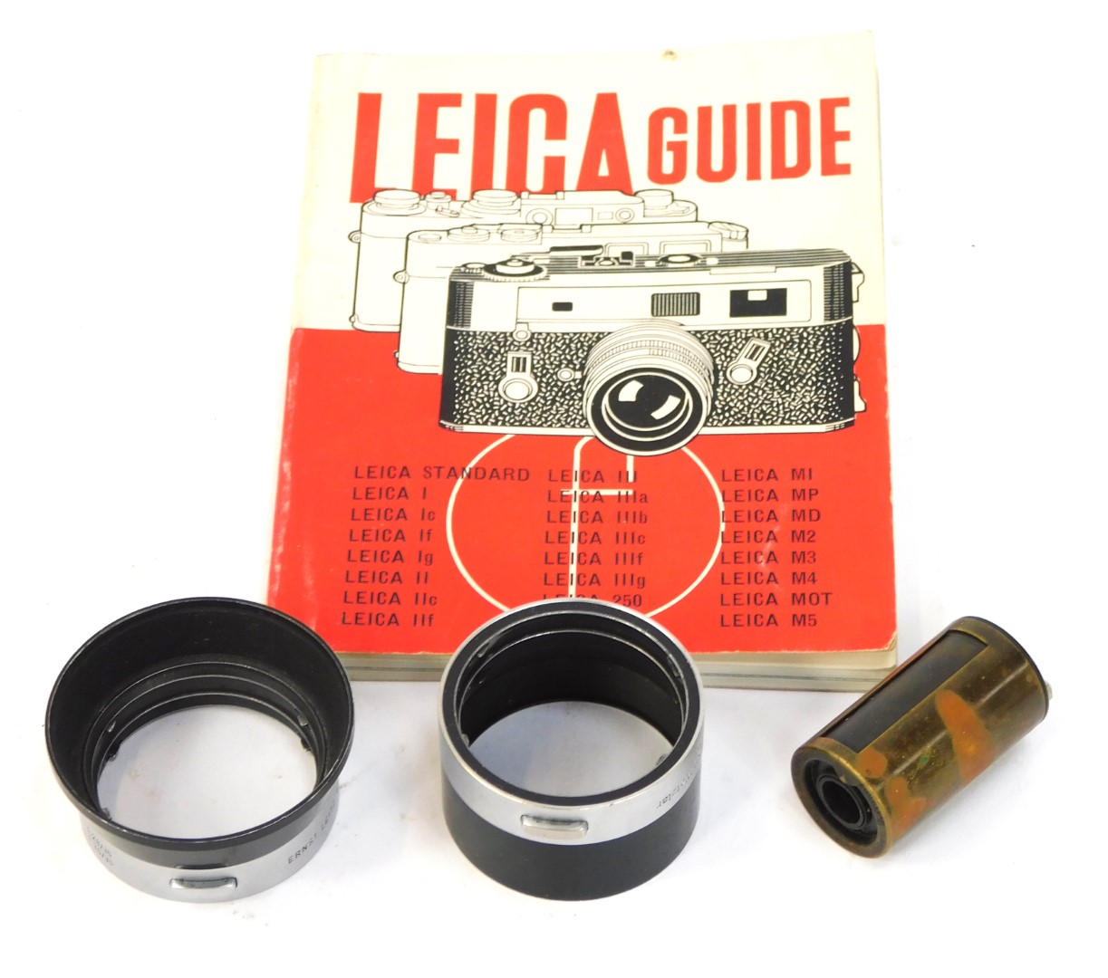 A Leica Reloadable cassette, 50mm lens hood, and a Leica guide book. (3)