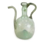 A blown glass jug, possibly 18thC, with a handle and shaped spout, with inverted base, green in colo