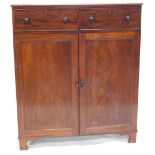 A Regency mahogany cabinet, with two drawers over two panelled doors with press interior drawers, on