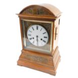A 19thC walnut cased cuckoo clock, the 18cm diameter Roman numeric dial, in an arched case with a
