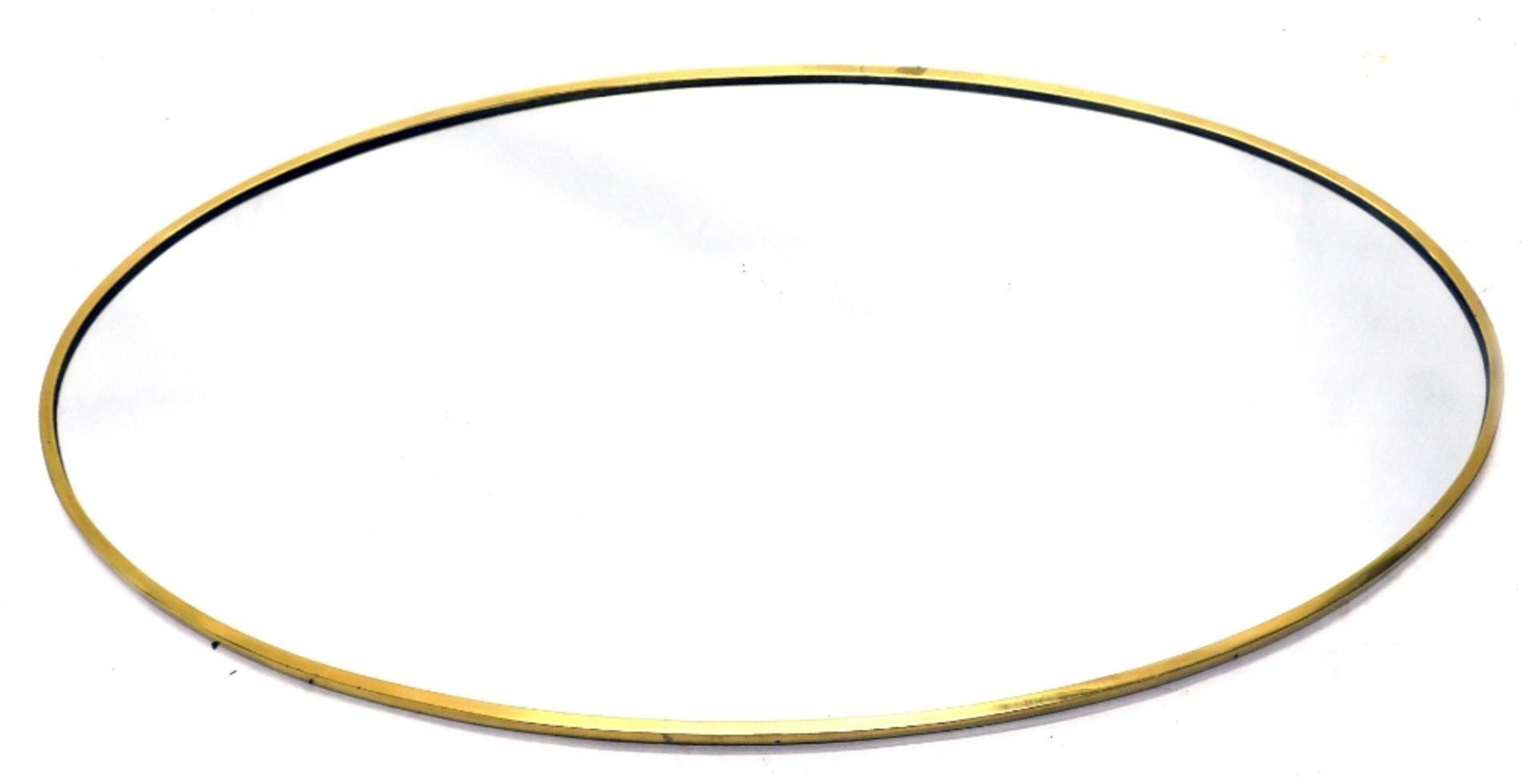 An oval brass wall mirror, of plain form, with chipboard backing, 101cm high, 58cm wide.