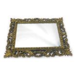 A Florentine style wall mirror, the rectangular plate surround by rococo scrolls, leaves, etc., 114c