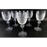 A set of six Waterford crystal drinking glasses with a hobnail cut decoration on turned stems and ci