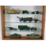 A glazed display cabinet, containing various Dinky and other diecast army trucks, etc., the cabinet