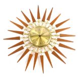 A Paico teak gilt metal sun burst wall clock, 52cm wide.