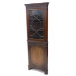A mahogany freestanding corner cabinet, the dentil top with a blind fret, above an astragal glazed d