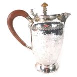 A George V Arts and Crafts silver hot water jug, by A. E. Jones Ltd, with wooden lock and compositio