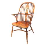 A 19thC ash and elm Windsor armchair, with a pierced splat, spindle turned supports and a solid seat