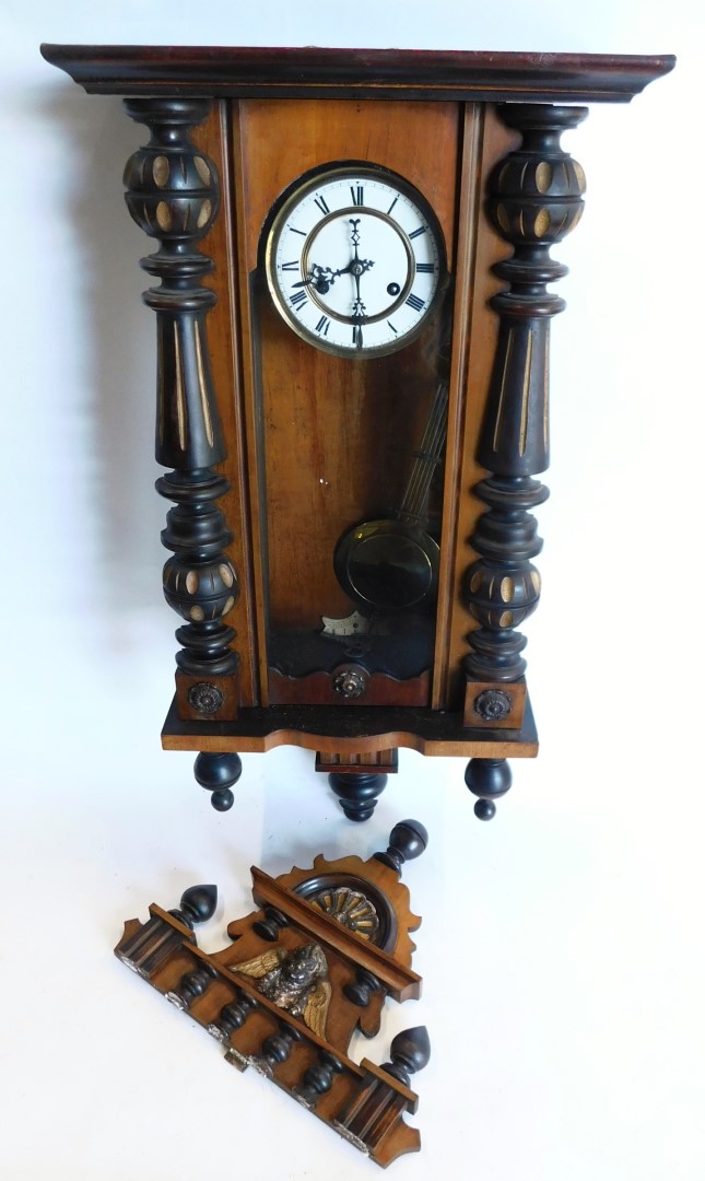 A late 19th/early 20thC Vienna wall clock, in a walnut and ebonised case, the enamel dial with Roman