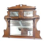 A late 19th/early 20thC walnut overmantel mirror, with a shaped cornice above two bevel mirror plate