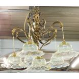 A brass Art Nouveau design five branch chandelier, set with six vaseline glass shades, on an entwine