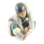 A Lladro porcelain figure of a seated girl, with mottle glazes, 17cm high.