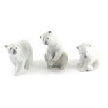 Three Lladro polar bears, two seated, one walking, the largest 15cm high.