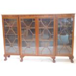 An early 20thC flame mahogany breakfront bookcase, in the Chippendale manner, with gadrooned top, fo