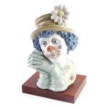 A Lladro bust of a clown, on wooden base, 31cm high. (AF)