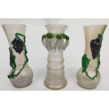 A pair of early 20thC Loetz style ribbed glass vases, each raised with berries and vines, in green o