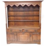 A 19thC Arts and Crafts dresser, with plate rack top, having rose carved frieze, bobbin turned suppo