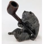 An early 20thC Black Forest cast metal pipe holder, modelled as a seated bear, with a briarwood pipe