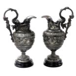 A pair of late 19thC white metal Cellini ewers, in the Renaissance style, with figural handles and l