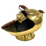 A reproduction beaten brass coal helmet scuttle, having turned treen handles, and a matching shovel.