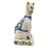 A late 19thC Dutch polychrome Delft ware figure of a cat, modelled in seated pose, its back painted