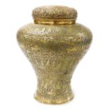 An Indian pierced brass jar and cover, the embossed lid decorated with flowers, etc., the base with