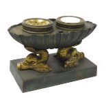 A late 19thC French brass and verdigris desk stand, of oval shell form, raised on double dolphin sup