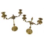 A pair of 19thC brass candelabra, with vertically adjustable arms, raised on an embossed foliate cir