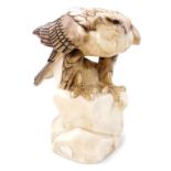 A 19thC Continental carved alabaster figure of a crouching eagle, perched on a stylised rock base, 3