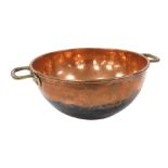 A late 19th/early 20thC hammered copper and brass mixing bowl, 62cm wide.