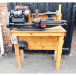 A Winfield lathe, mounted on an oak table top 132cm high, 90cm wide, 44cm deep. Buyer Note: WARNING!