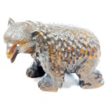 A Black Forest style carved model of a brown bear, in a slightly humorous standing pose, with glass