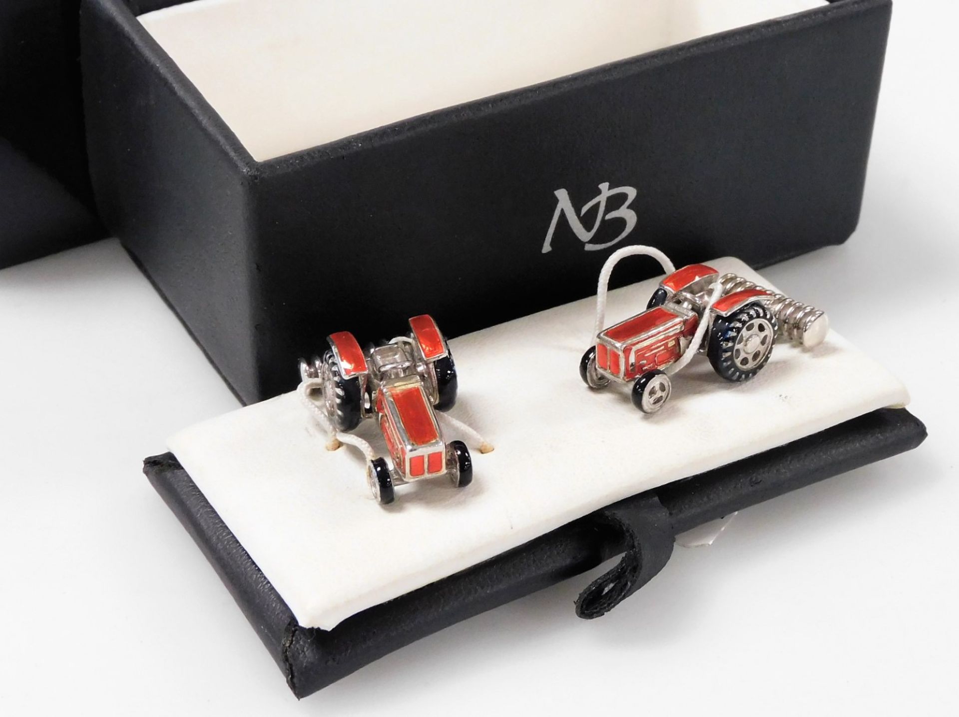 A pair of silver and red enamel cufflinks, modelled as tractors, boxed, 17.8g.