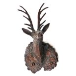 A Black Forest style carved deer shaped wall mask, the mount decorated with oak leaves, acorns, etc.