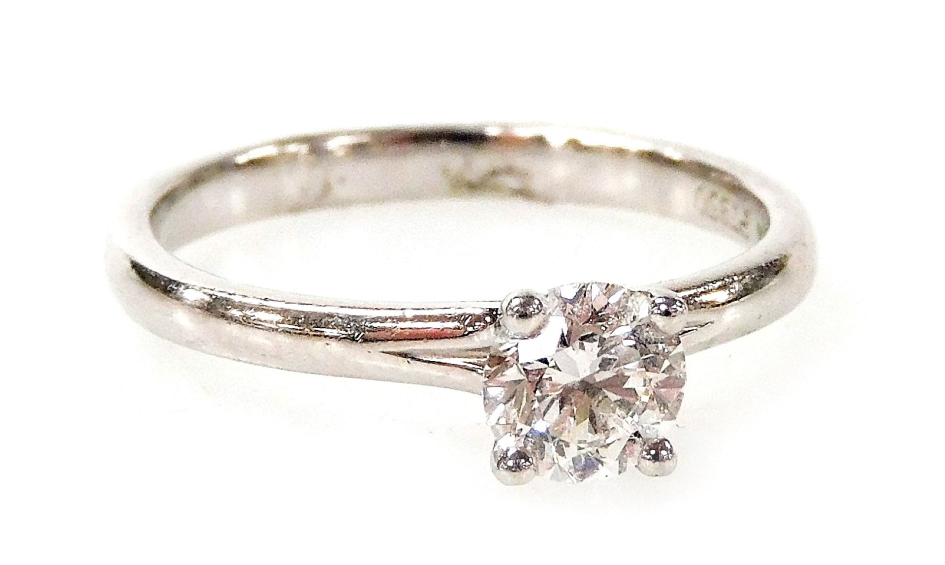 A platinum and diamond solitaire ring, with round brilliant cut diamond in four claw setting, 0.60ct