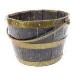 An oak and brass bound fire bucket, with a swing handle, 22.5cm high, 30cm wide.