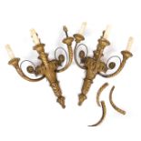 A pair of early 20thC giltwood three branch wall lights, with fluted and foliate carving, 49cm high.
