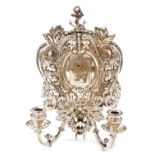 A Victorian Elkington electrotype silver plated wall sconce, the shield shaped back decorated with a