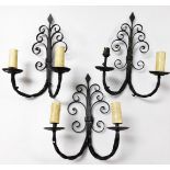 A set of three wrought iron twin branch wall lights, of scrolling form, 21cm high.