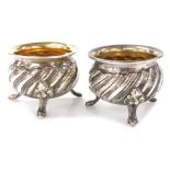 A pair of 19thC French silver open salts, each of circular part fluted form raised on three lion's p