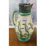 A Myott and Son pottery jug, decorated with abstract flowers and leaves, with pale and dark green ba