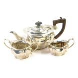 A George V silver three piece tea set, comprising teapot, milk jug, sugar bowl, with fluted body, an