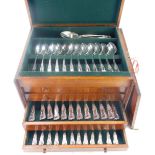 A canteen of silver plated kings pattern flatware, twelve place settings, in a stained pine chest wi